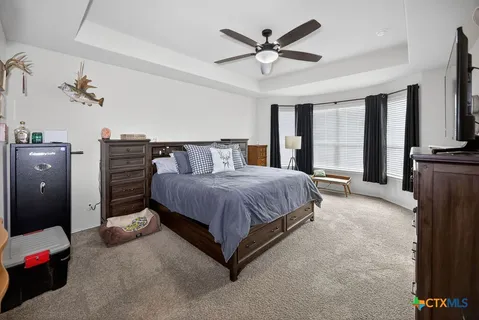 a spacious bedroom with a bed and a chandelier