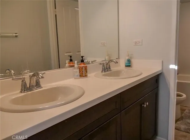 a bathroom with double vanity sink and a mirror