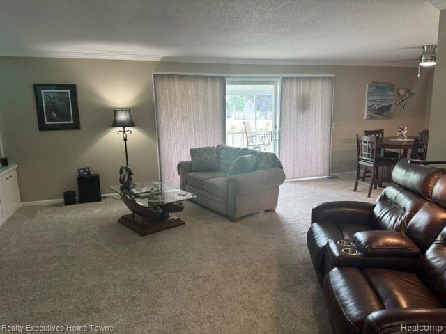 1467 Krafft Road, Unit 8 Port Huron, MI 48060 - Photo 4 of 28 Carpeted living area featuring a sliding glass door with vertical blinds, leading to an outdoor patio with additional seating