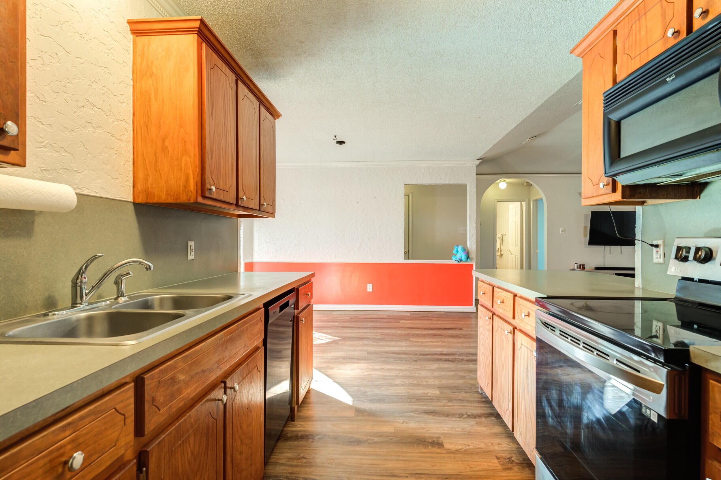 6325 14th Street Lubbock, TX 79416 - Photo 13 of 28 a kitchen with stainless steel appliances granite countertop a sink a stove and a wooden cabinets
