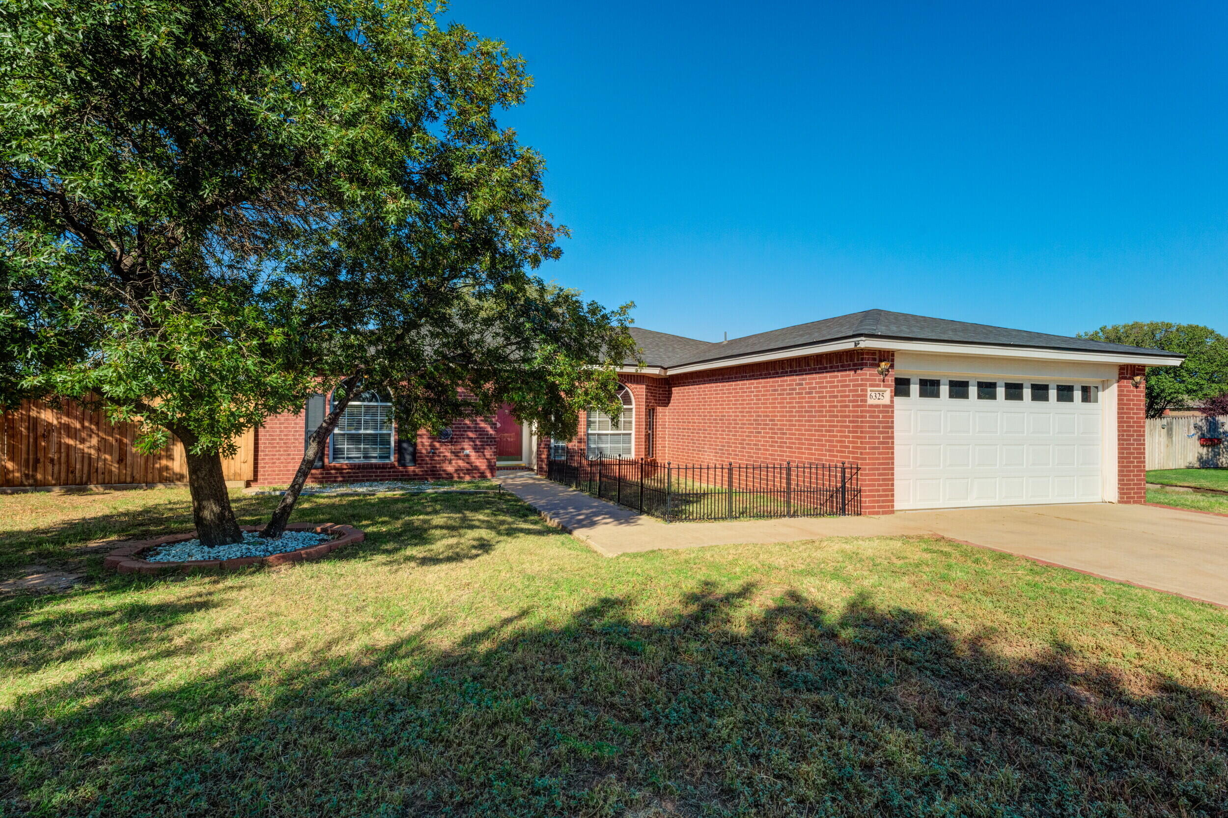 6325 14th Street Lubbock, TX 79416 - Photo 3 of 28 a view of a house with a yard and garage