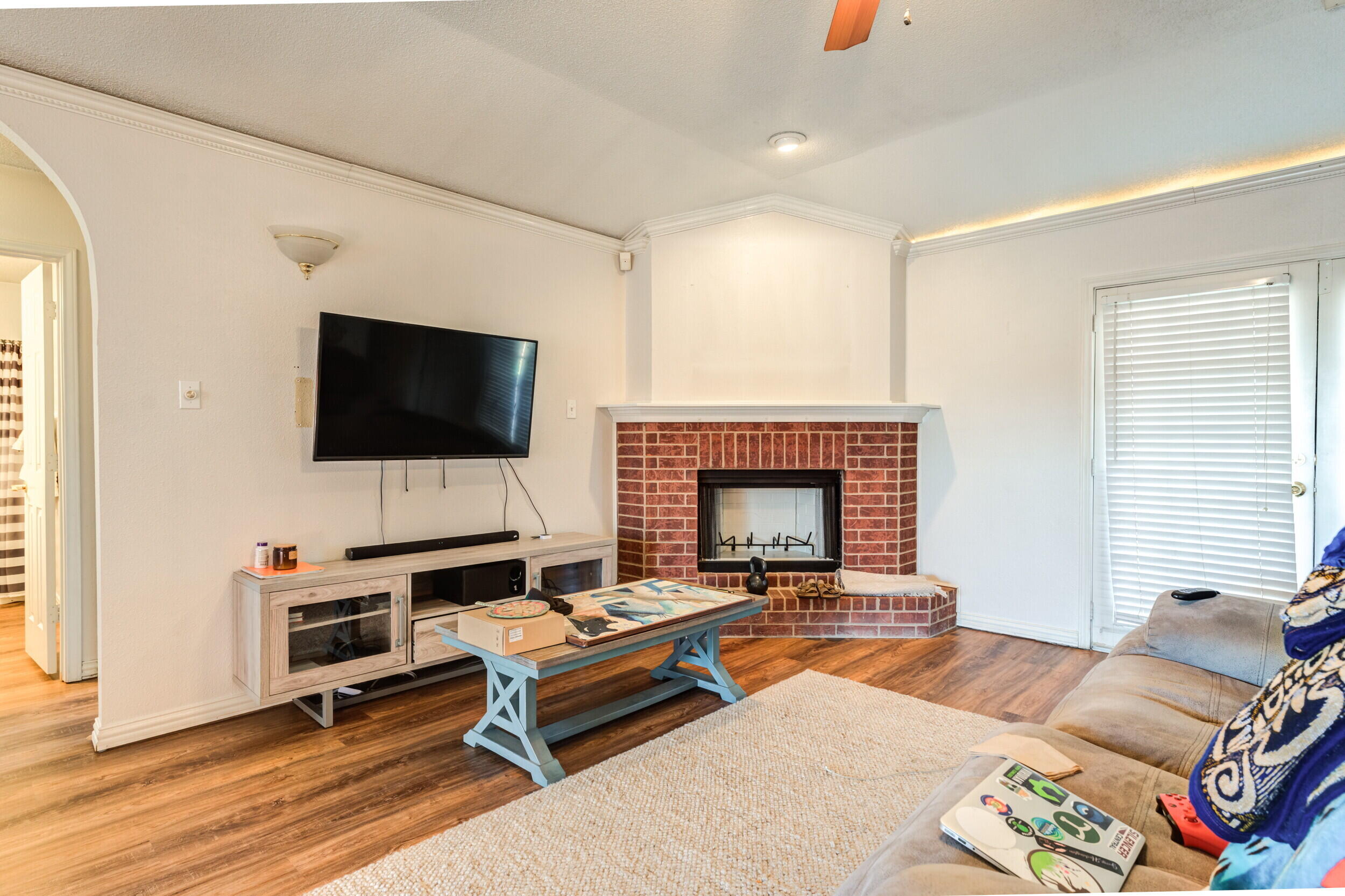 6325 14th Street Lubbock, TX 79416 - Photo 5 of 28 a living room with furniture a flat screen tv and a fireplace
