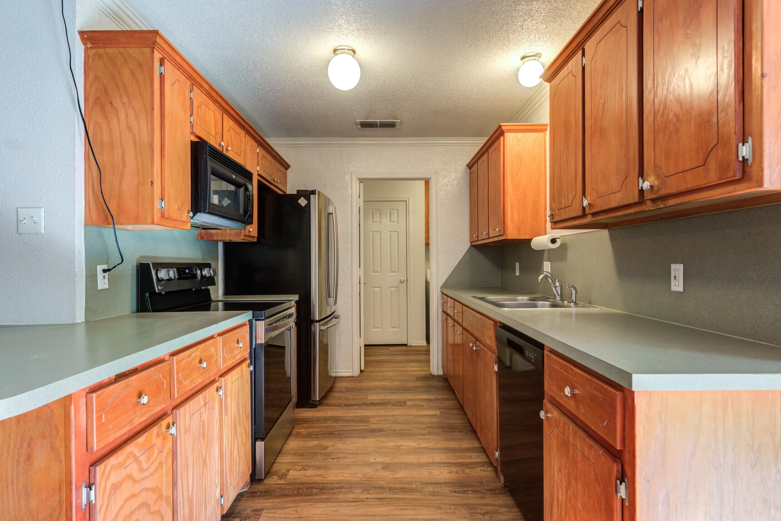 6325 14th Street Lubbock, TX 79416 - Photo 9 of 28 a kitchen with stainless steel appliances granite countertop a stove a sink and a refrigerator