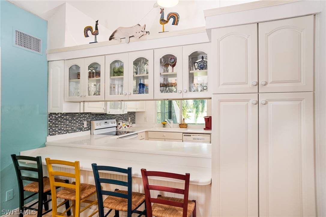 1031 Sand Castle Road Sanibel, FL 33957 - Photo 6 of 27 a kitchen with stainless steel appliances granite countertop a white cabinets and a refrigerator
