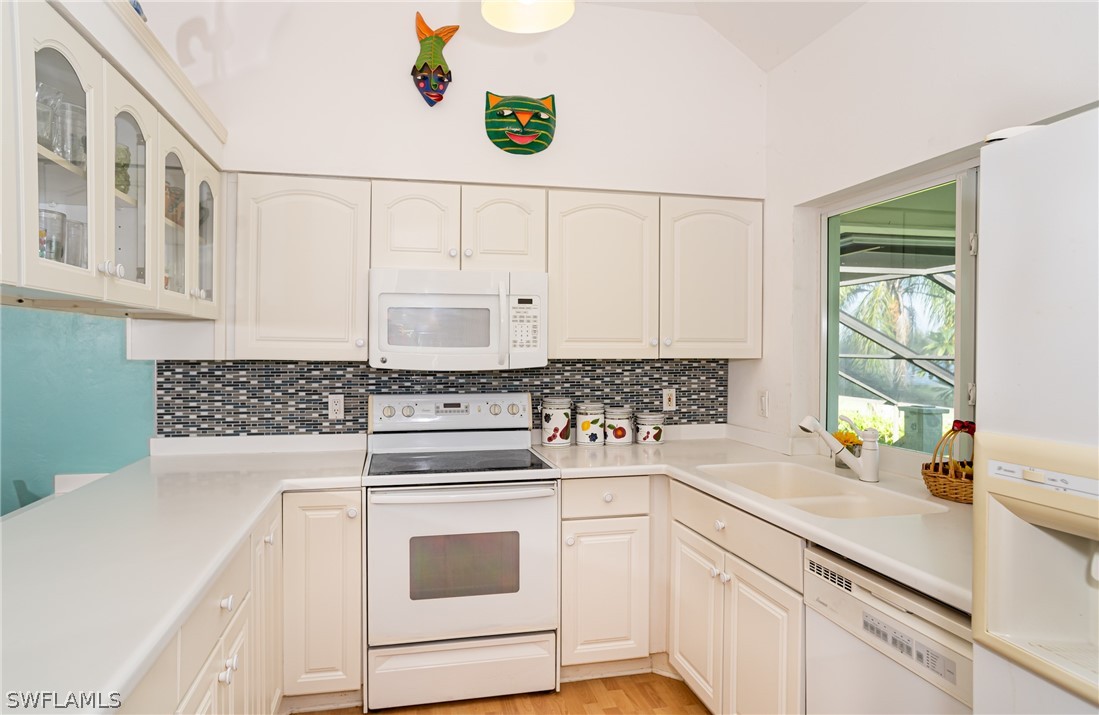 1031 Sand Castle Road Sanibel, FL 33957 - Photo 7 of 27 a kitchen with cabinets appliances a sink and a counter top space