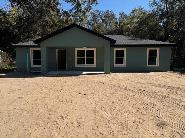 a front view of a house with a yard covered in snow