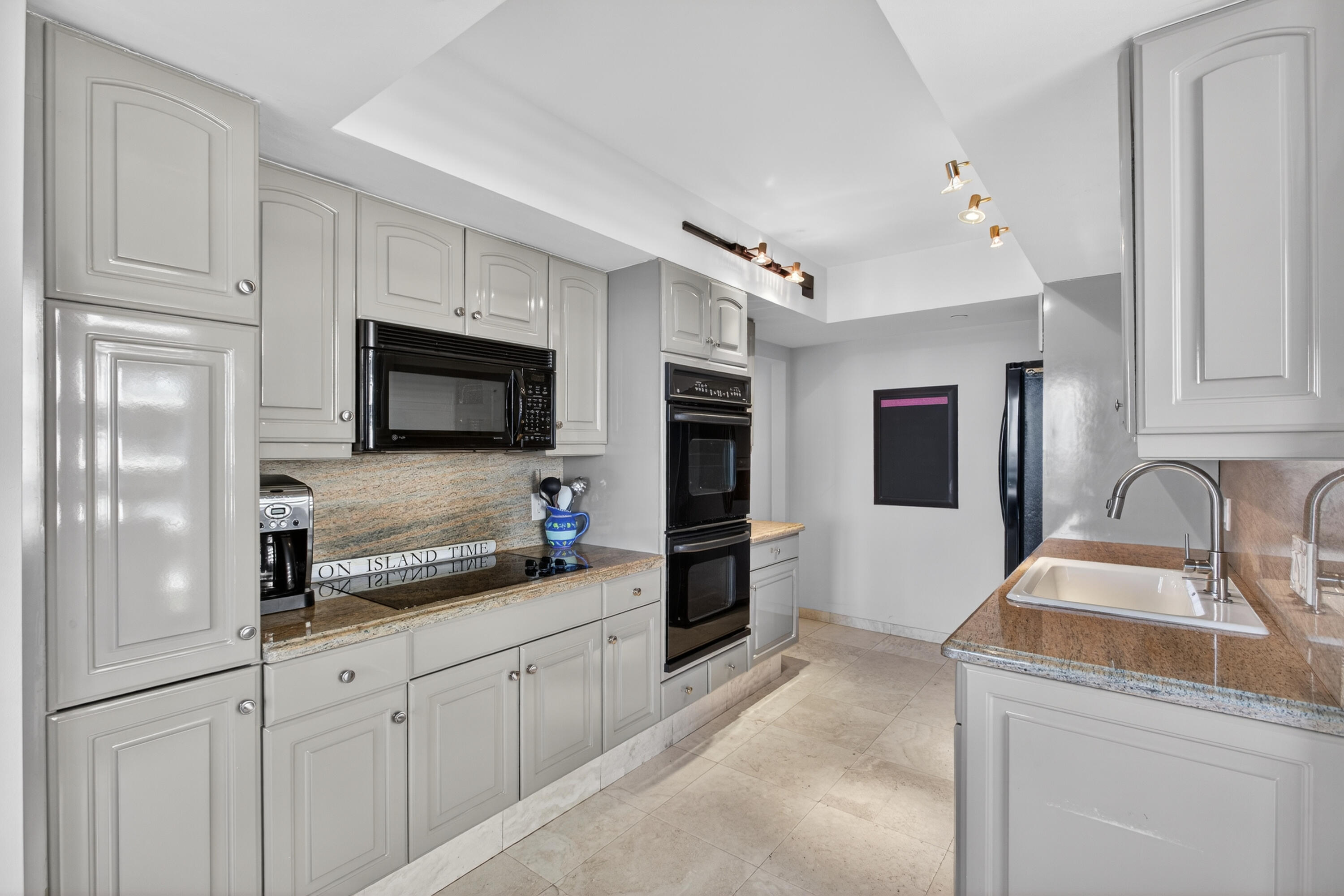 4050 North Ocean Drive, Unit 301 Riviera Beach, FL 33404 - Photo 17 of 62 a kitchen with stainless steel appliances granite countertop a sink and a refrigerator