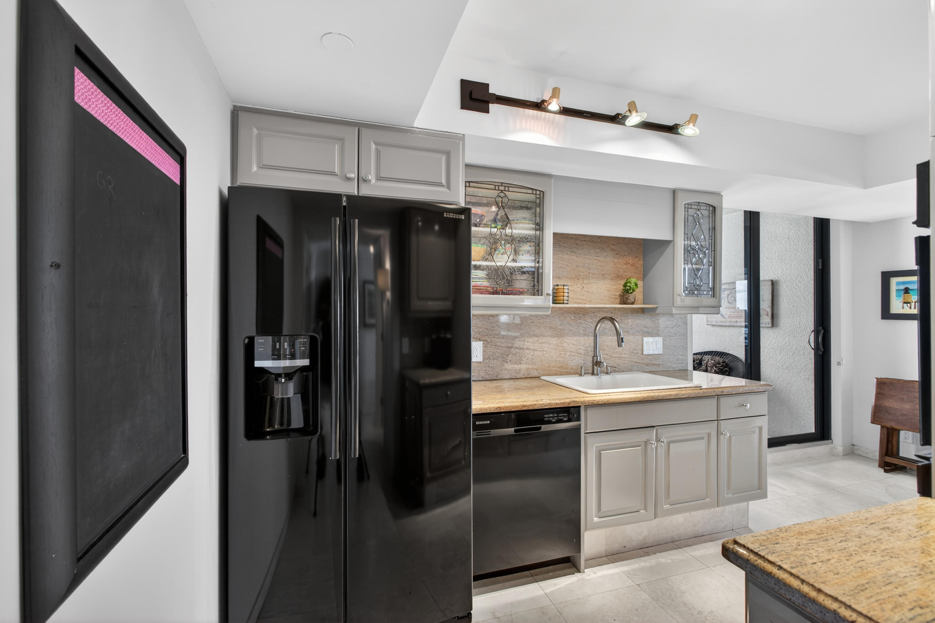 4050 North Ocean Drive, Unit 301 Riviera Beach, FL 33404 - Photo 18 of 62 a kitchen with a sink a refrigerator and cabinets