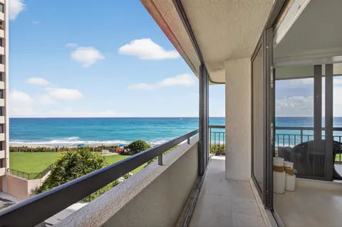 a living room with patio furniture and a chandelier