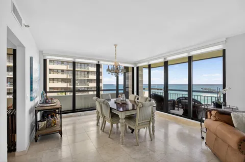 a living room with furniture a rug a lamp and a large window