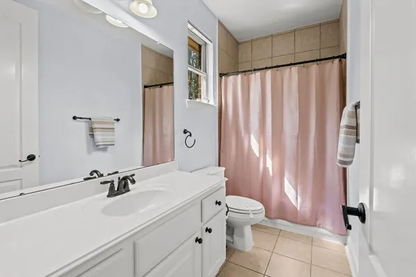 a bathroom with a sink a toilet and shower curtain