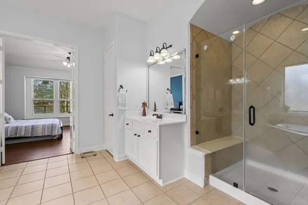 a spacious bathroom with a tub sink and mirror