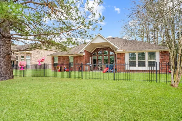 a view of a house with a big yard and large trees