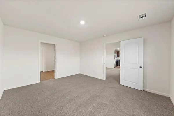 a view of an empty room with closet and a window