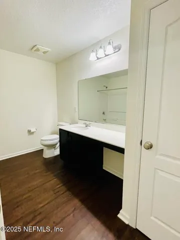 a en suite bathroom with a granite countertop sink and a mirror