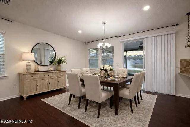 a dining room with furniture a rug and a mirror