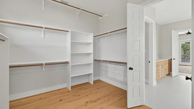 a view of walk in closet with empty racks