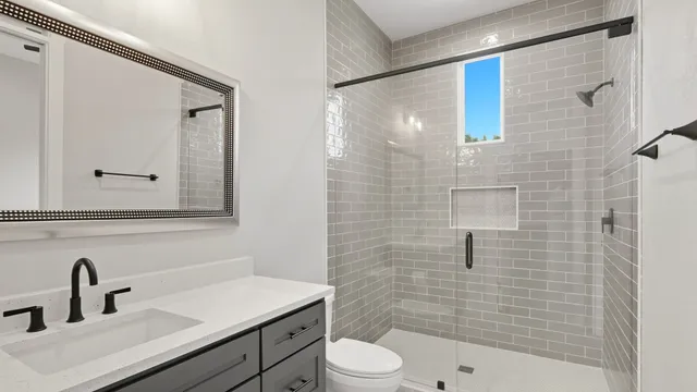 a bathroom with a sink a toilet and shower