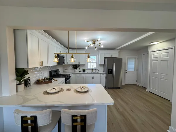 a kitchen with a sink a kitchen island and stainless steel appliances