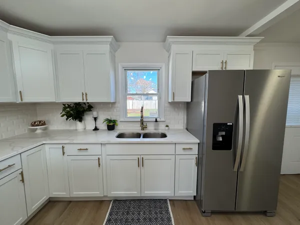a kitchen with stainless steel appliances a refrigerator a sink and cabinets