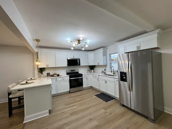 a kitchen with kitchen island granite countertop stainless steel appliances cabinets a sink and a stove