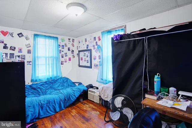 a bedroom with a bed and a refrigerator