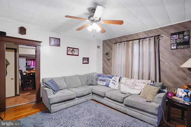 a living room with furniture and a ceiling fan
