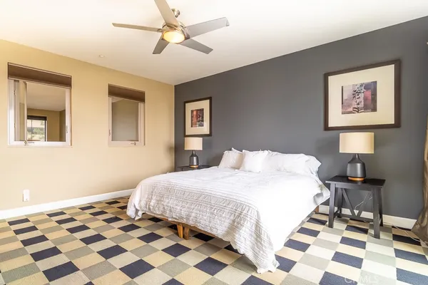 a bedroom with a bed and a lamp on a dresser