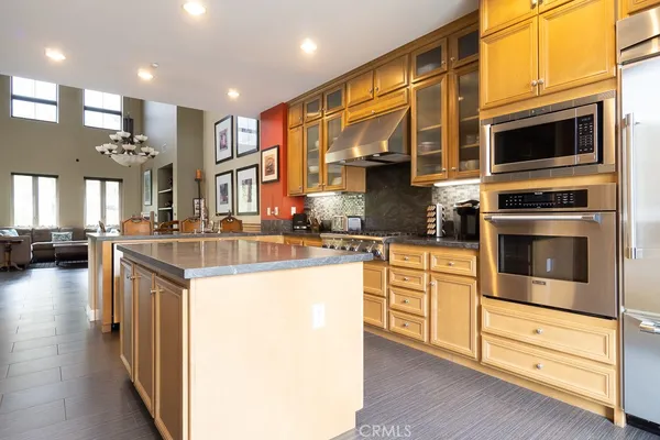 a kitchen with stainless steel appliances kitchen island granite countertop a stove and a sink