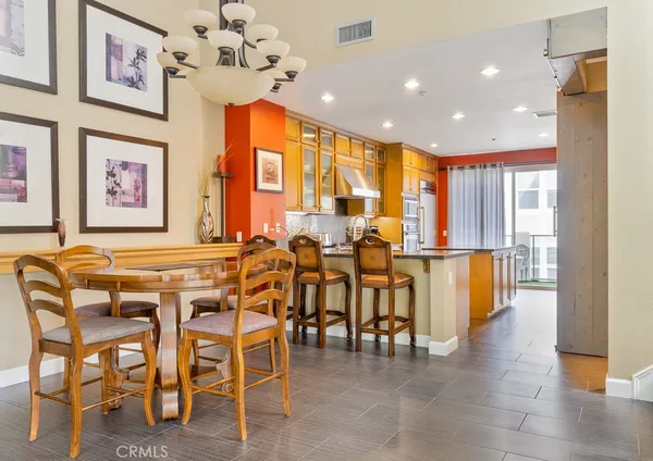a view of a dining room with furniture a chandelier and wooden floor