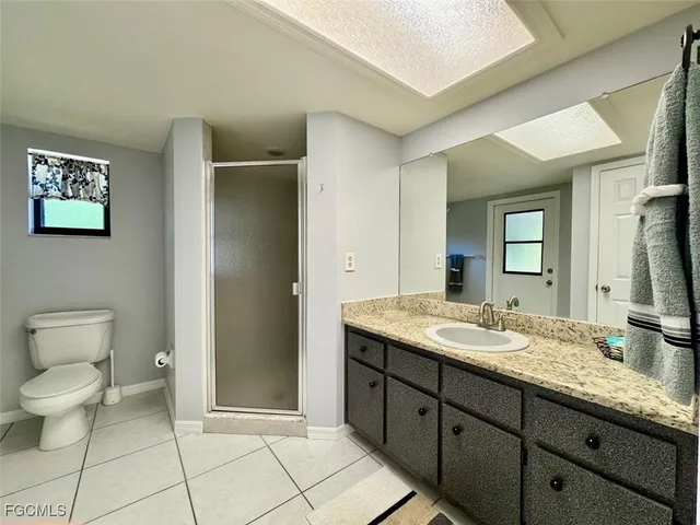 a spacious bathroom with a granite countertop sink toilet and mirror