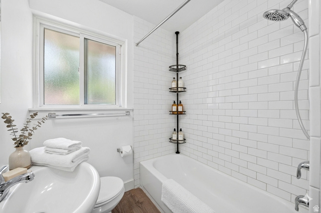 7879 Oak Street Midvale, UT 84047 - Photo 15 of 32 Bathroom featuring a full tub with subway tile surround, chrome fixtures, and a shower head with hose attachment