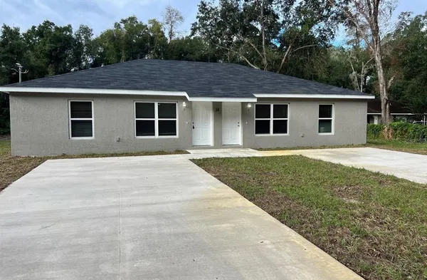 a front view of house with yard and trees around