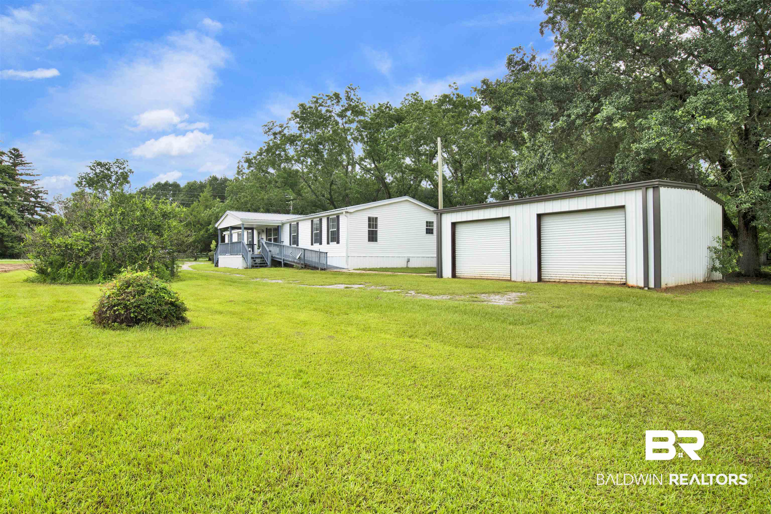 25700 County Road 71 Robertsdale, AL 36567 - Photo 27 of 40 Back of house with a yard, an outbuilding, a detached garage, and view of scattered trees