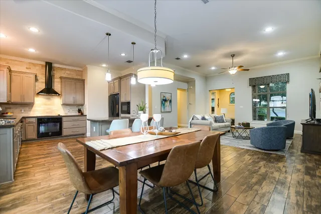 a view of a dining room and livingroom with furniture wooden floor a chandelier