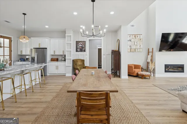 a living room with kitchen island furniture and a chandelier