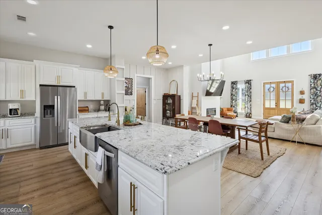 a large kitchen with granite countertop lots of counter space dining table and stainless steel appliances