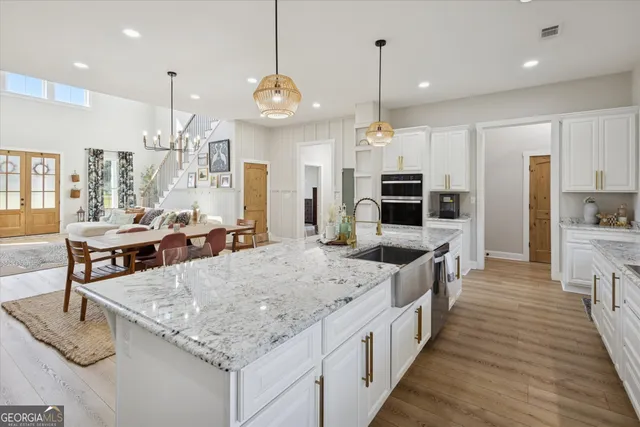 a large kitchen with stainless steel appliances kitchen island granite countertop a large island in the center