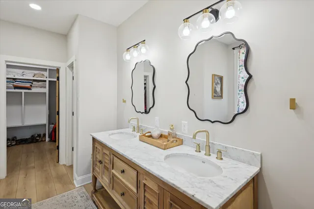 a bathroom with a granite countertop double vanity sink and a mirror