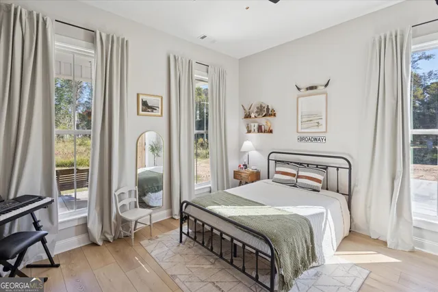 a bedroom with a bed a mirror and a window