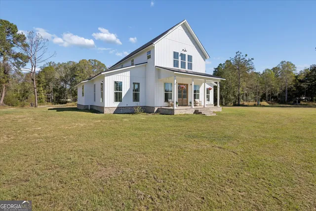 a front view of house with yard and trees in the background