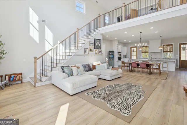 a living room with furniture and a dining table with wooden floor