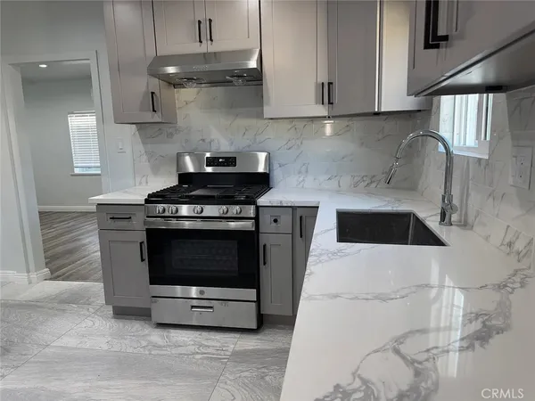 a kitchen with stainless steel appliances a stove a sink and a microwave