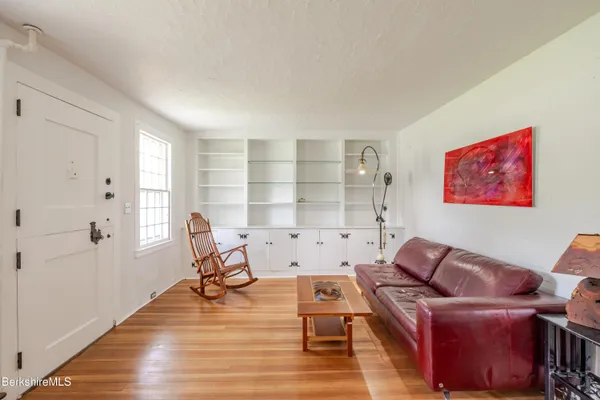 a bedroom with a bed windows and wooden floor