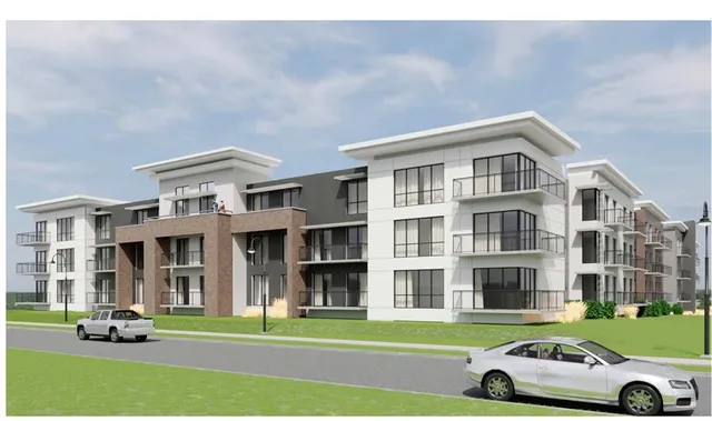 a car parked in front of a brick building next to a yard