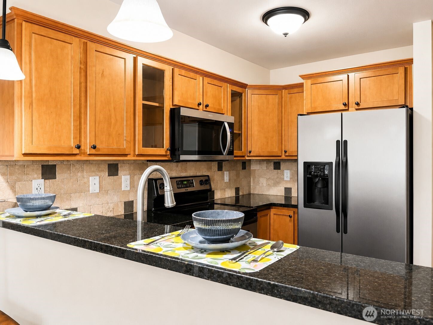 700 32nd Street, Unit A309 Bellingham, WA 98225 - Photo 6 of 28 a kitchen with stainless steel appliances granite countertop a refrigerator a stove top oven a sink and cabinets