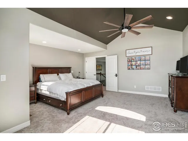 a spacious bedroom with a bed and a flat screen tv