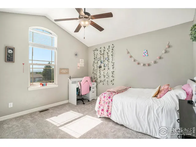 a bedroom with a bed a window and a potted plant