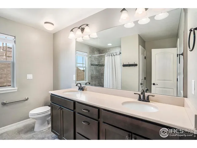 a bathroom with a double vanity sink mirror and toilet