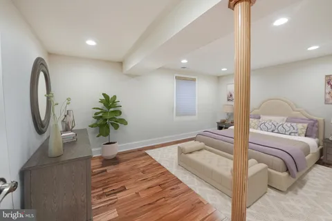 a spacious bedroom with a bed and a potted plant